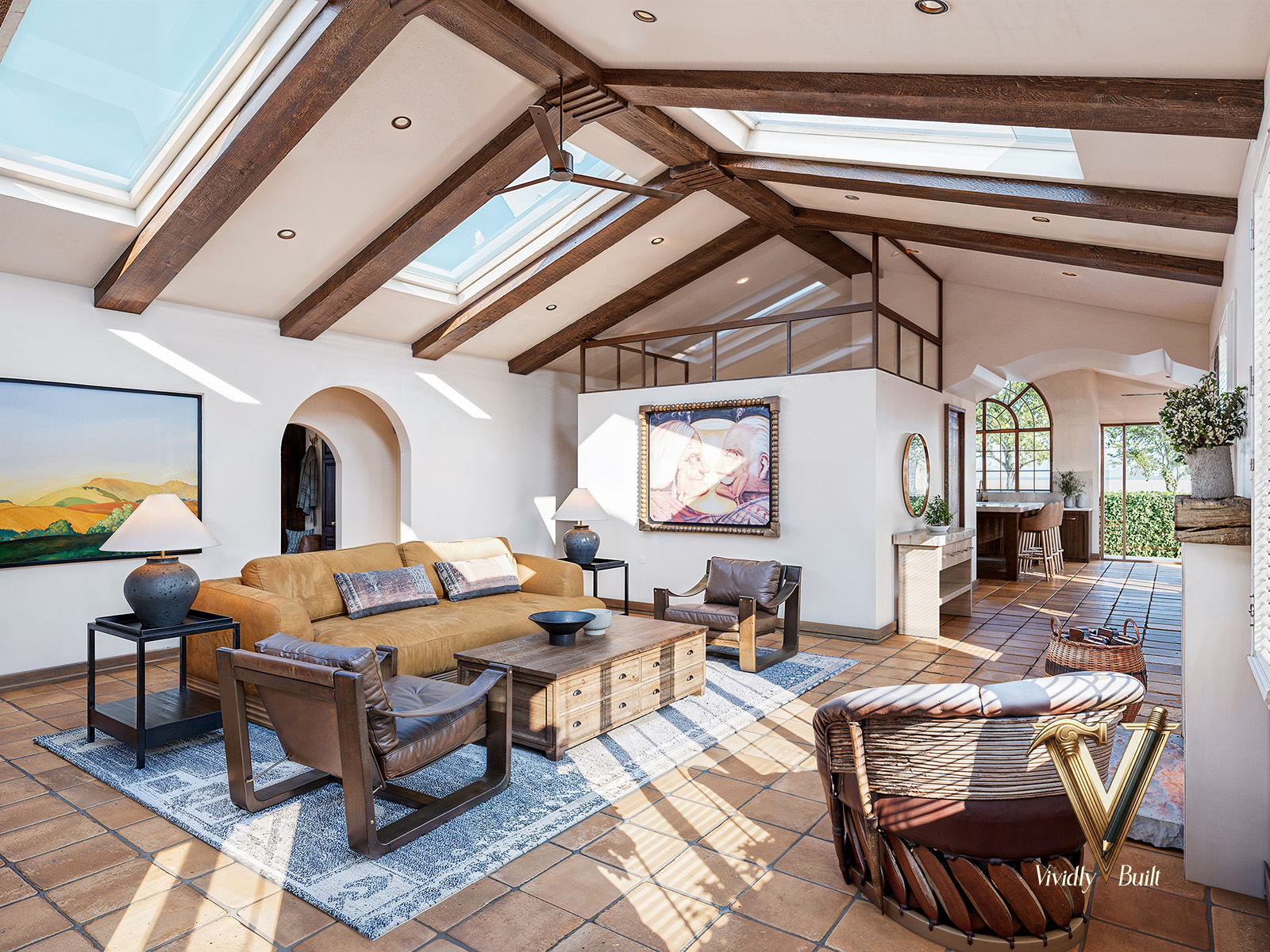 Vaulted-beam Mediterranean living room with skylights, art vignettes, and sightline through to the kitchen — Mediterranean Estate, Pasadena