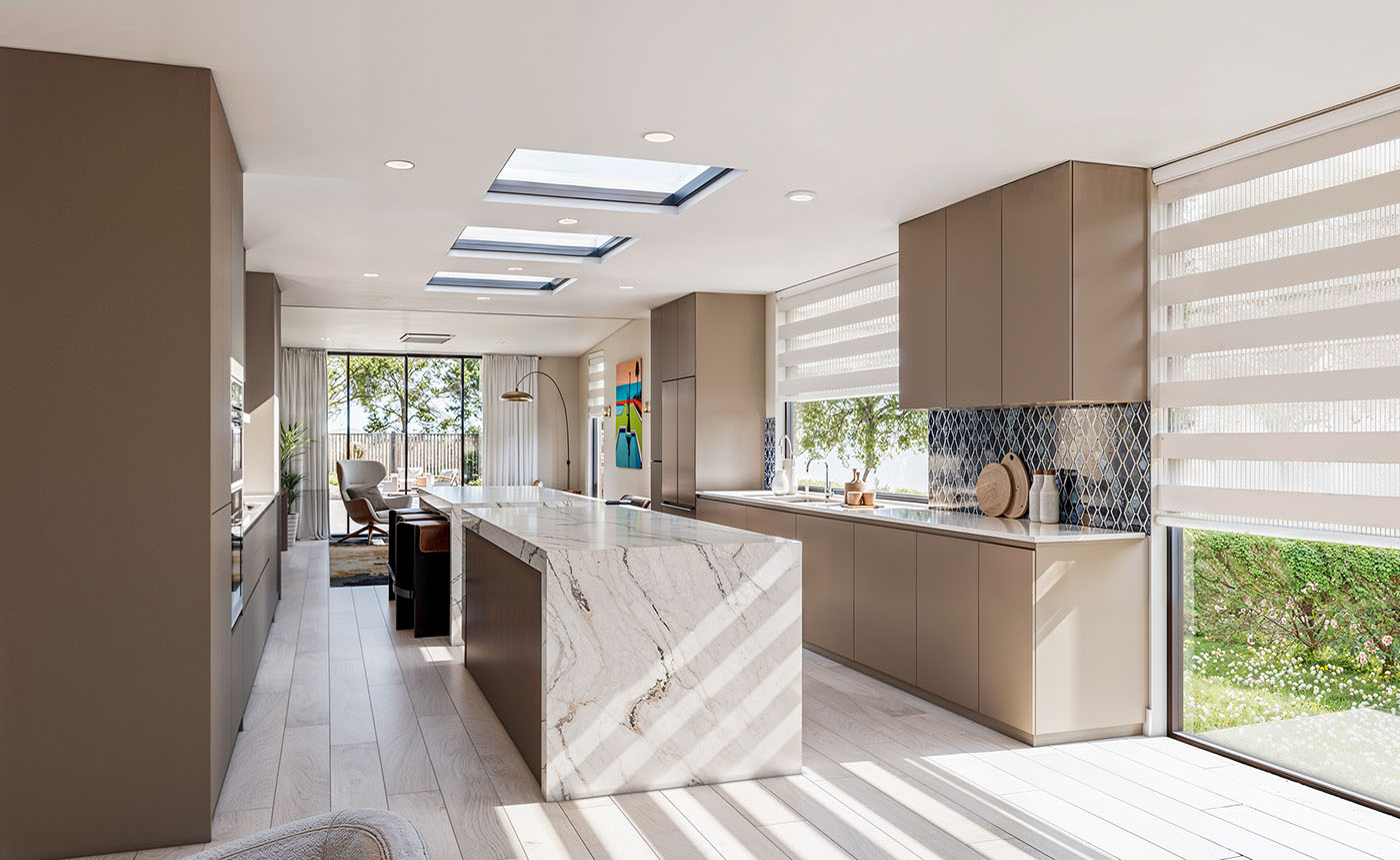 The same kitchen redesigned as one open plan with a waterfall island and skylights - Santa Monica Spanish bungalow after remodel by Vividly Built
