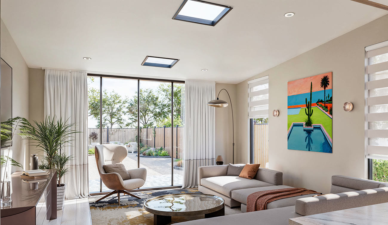 The same room redesigned as a modern coastal living room, the French doors replaced by a full-height glass wall to the garden, with skylights - Santa Monica bungalow after remodel by Vividly Built